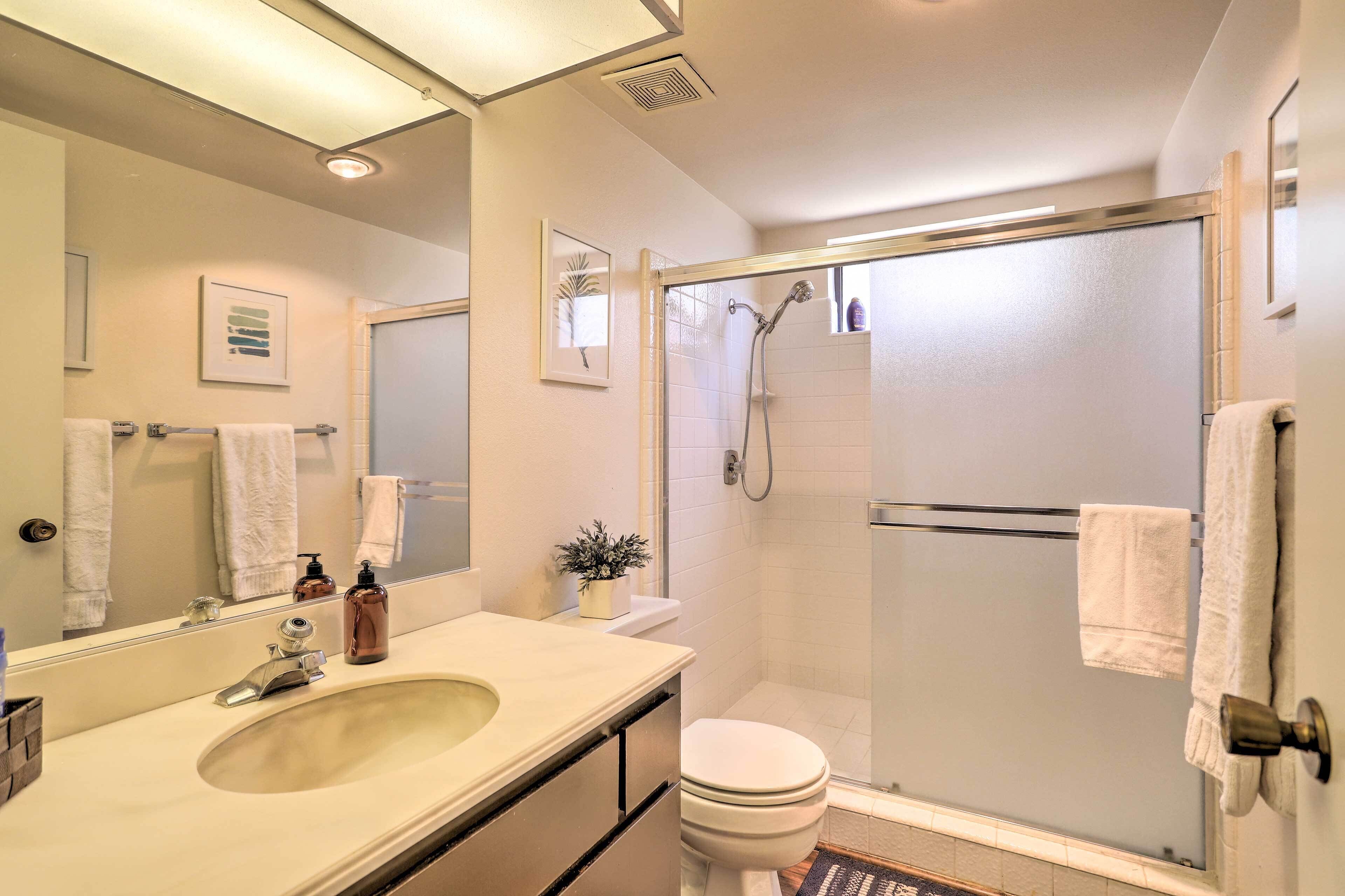 A bathroom with a sink, toilet, and glass-enclosed shower.