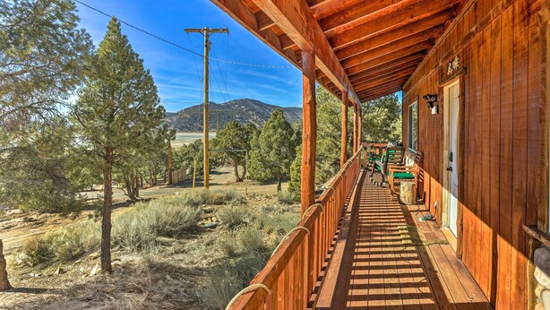 A wooden porch with a view of a mountainous landscape.