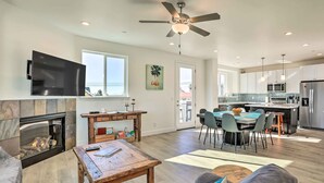 A spacious living area with a fireplace, a dining table, and a kitchen in the background. - Stunning Getaway < 1 Mi to Grover Beach! (Grover Beach)