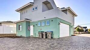 A modern house with a unique angular design, a garage, and three trash bins in front. - Stunning Getaway < 1 Mi to Grover Beach! (Grover Beach)