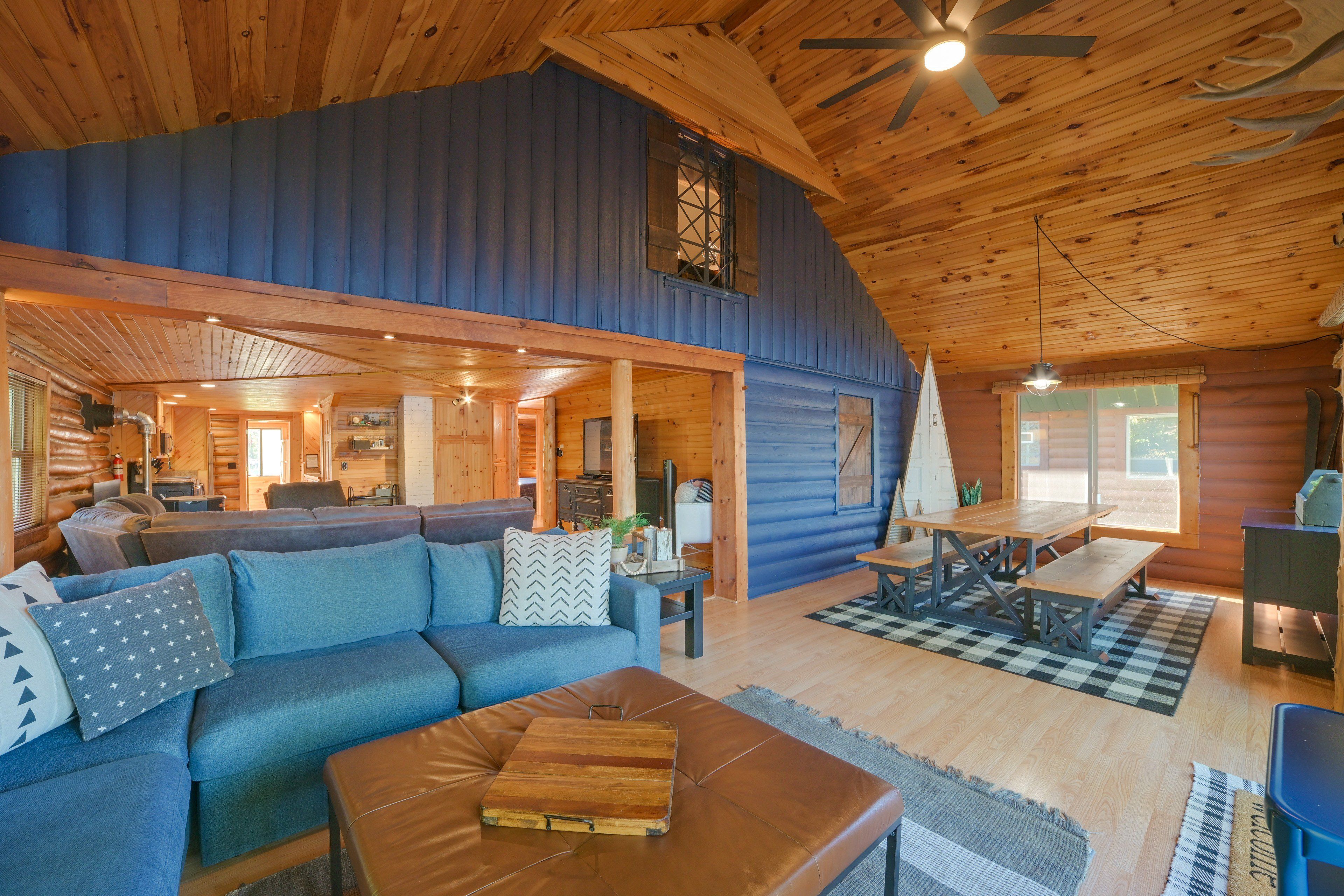 A spacious cabin interior with a large living area, a dining table, and a cozy seating arrangement.