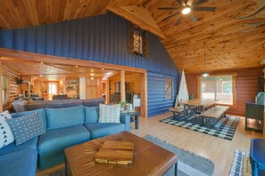 Un interior de cabaña espacioso con una amplia sala de estar, una mesa de comedor y una zona de estar acogedora.
