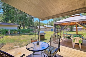 A covered patio area with a table and chairs, a grill, and a view of the backyard. - Fredericksburg Home 8 Blocks to Main St + Wineries (Fredericksburg)