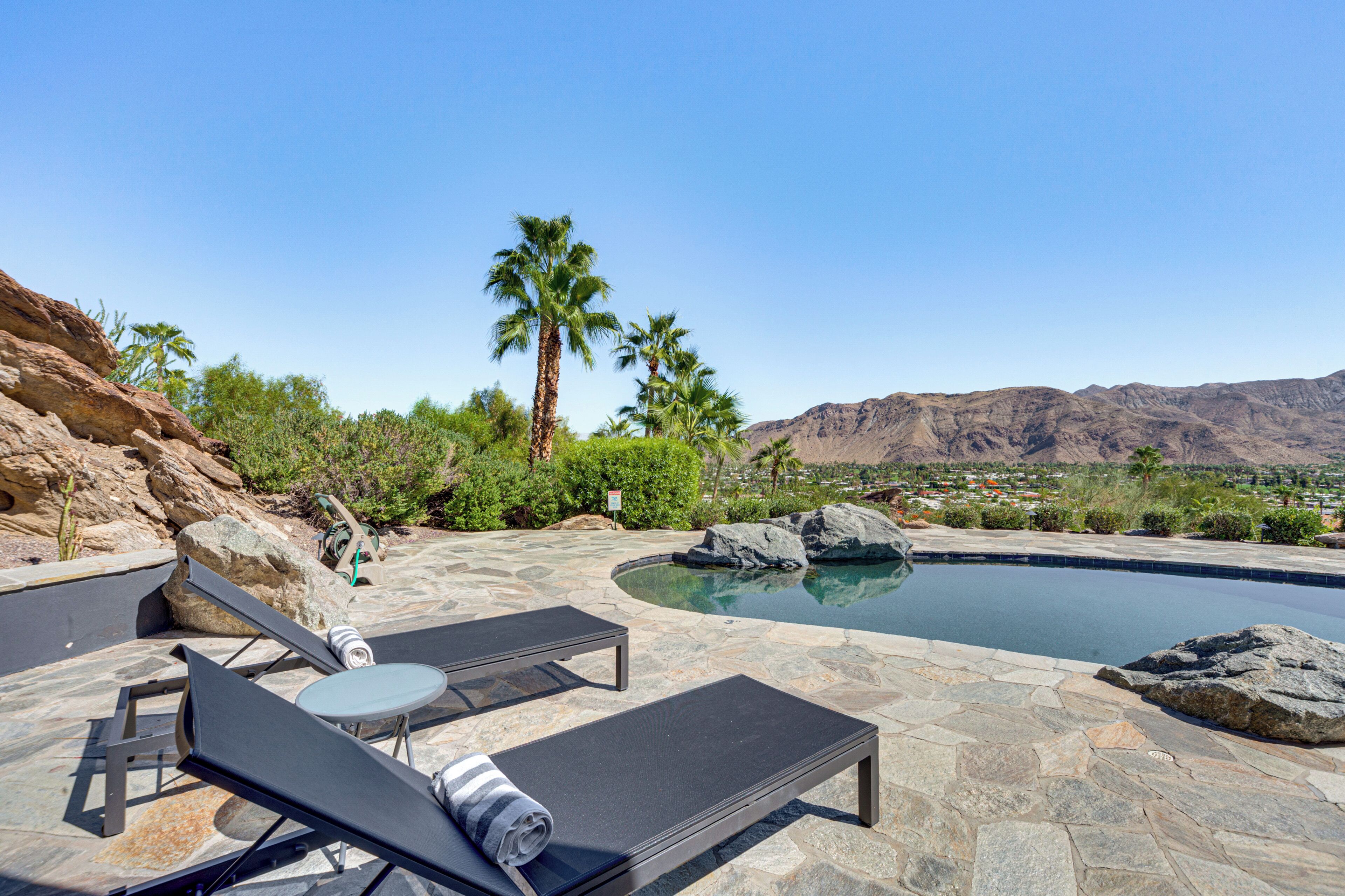 A poolside area with lounge chairs and a stone patio.