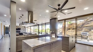 A modern kitchen with a large island, built-in appliances, and a view of a rocky outdoor area. - Palm Springs Retreat w/ Private Pool & Jacuzzi (Palm Springs)