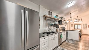 Een moderne keuken met roestvrijstalen apparatuur, witte kasten en een houten eiland.