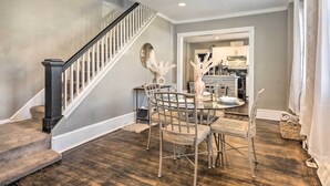 A dining area with a round table, chairs, and a staircase with a railing. - Baltimore Vacation Rental Near Dtwn Towson! (Baltimore)