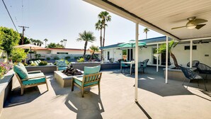 An outdoor patio area with lounge chairs, a table, and a covered seating area.
