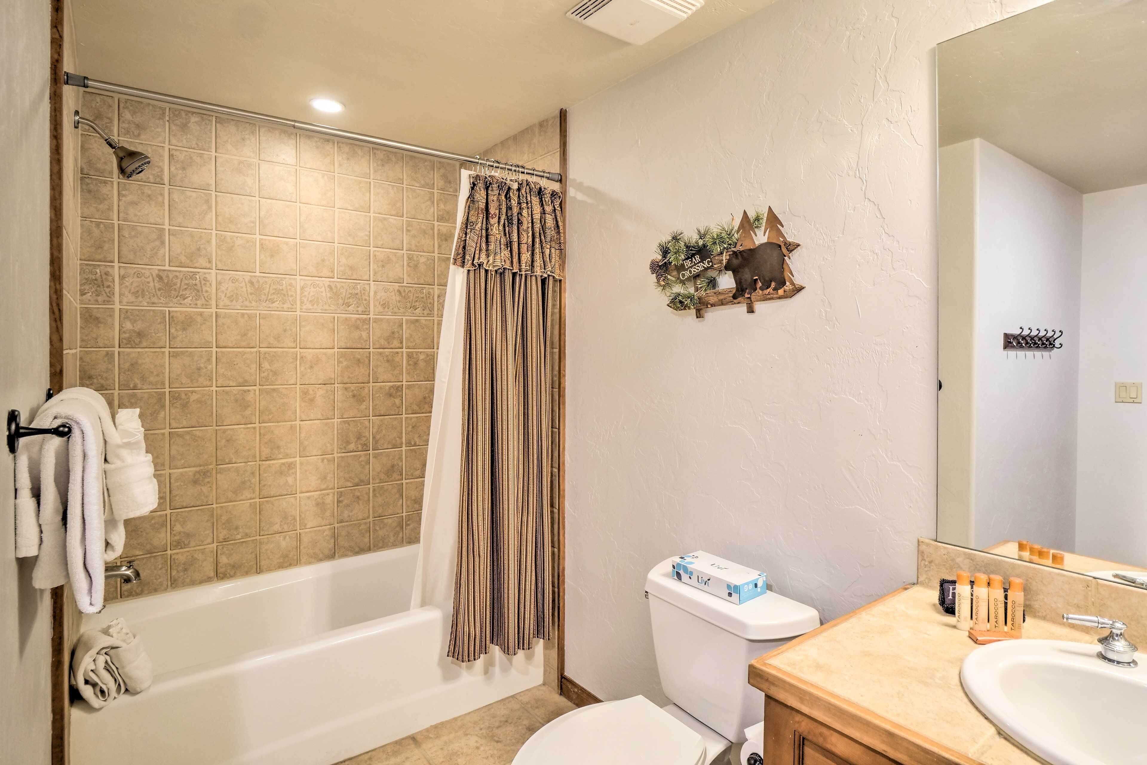 A bathroom with a bathtub, toilet, and sink.