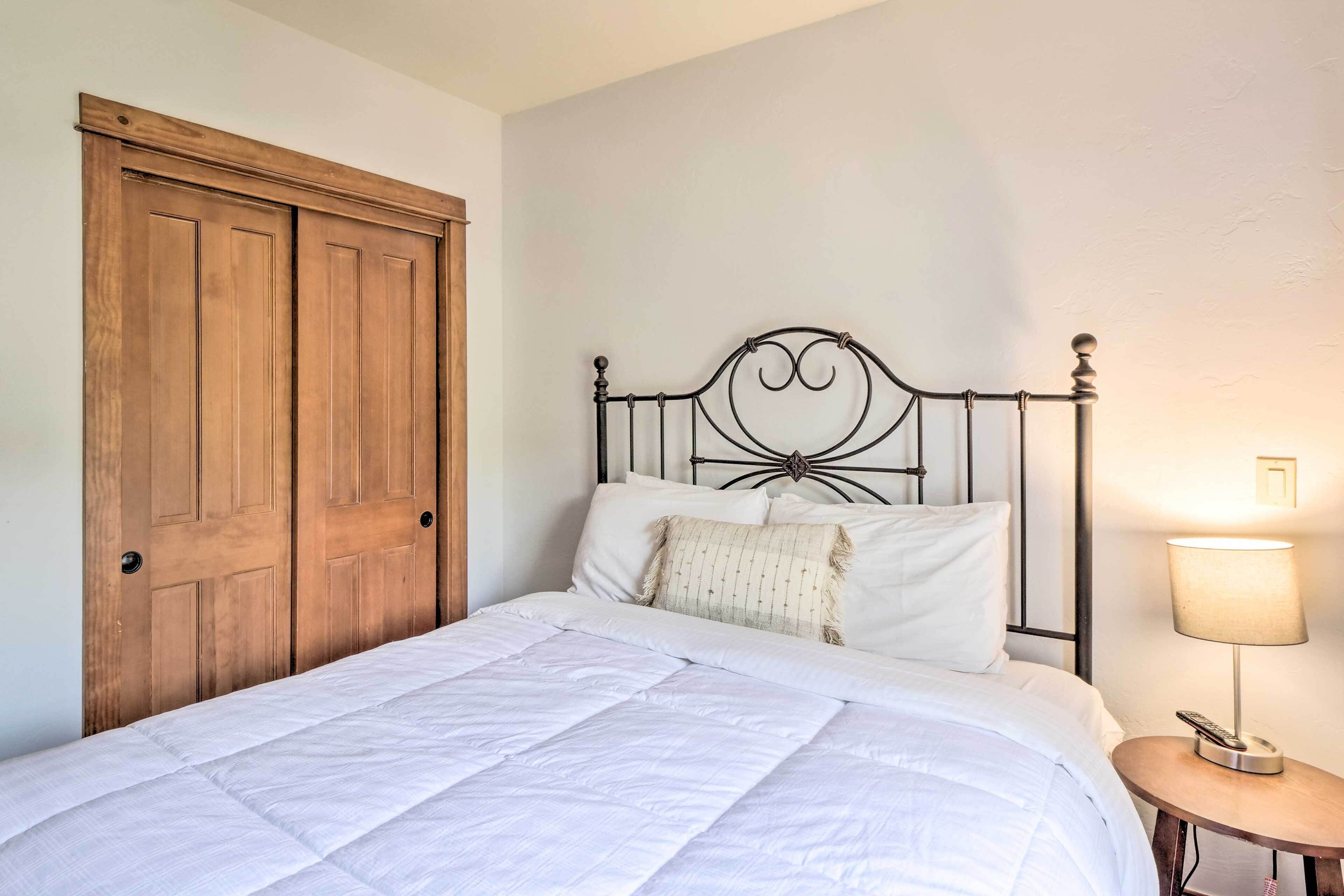 Una camera da letto con un letto, un'armadiatura in legno e un comodino con una lampada.