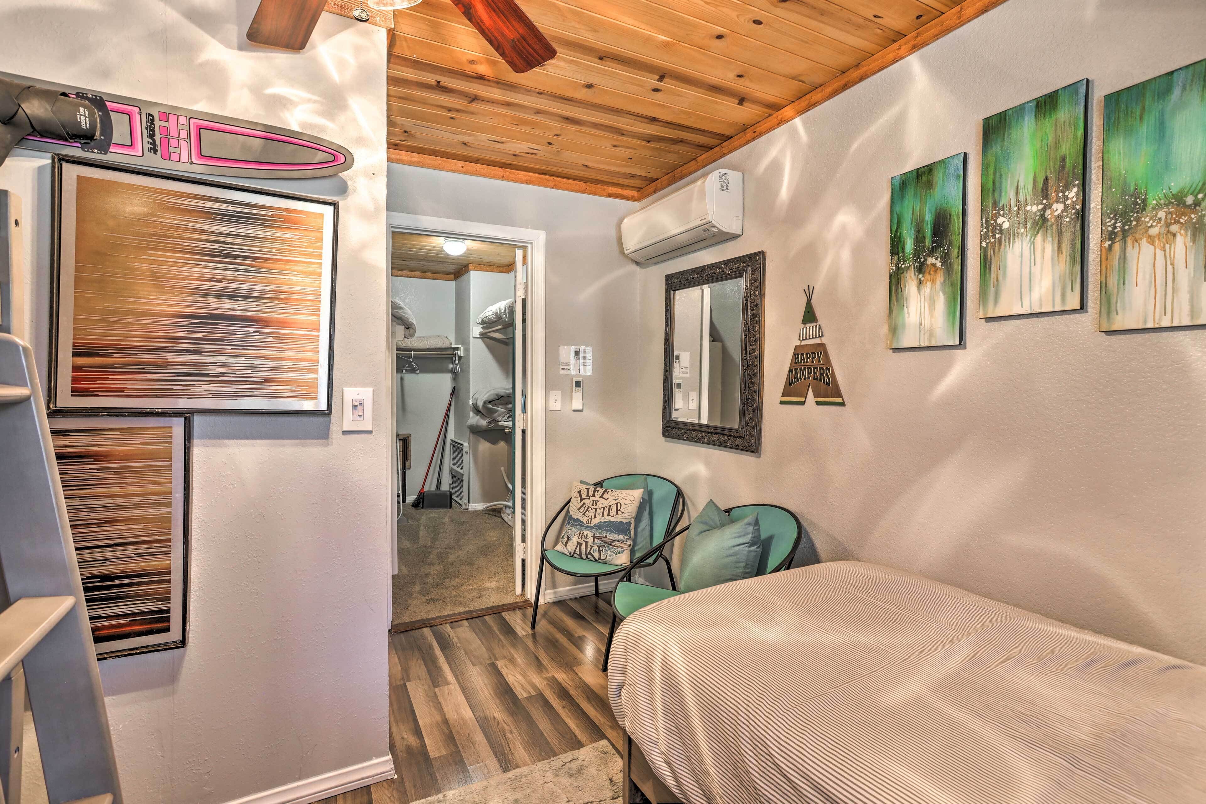 A bedroom with a bed, a chair, and artwork on the walls.