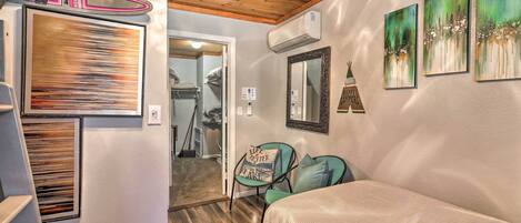 A bedroom with a bed, a chair, and artwork on the walls.