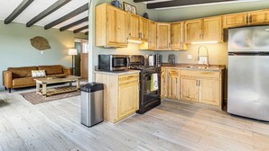A kitchen with wooden cabinets, a stainless steel refrigerator, a microwave, and a stove. - Group Friendly! Gem 5 Mi to Joshua Tree Nat'l Park (Joshua Tree)