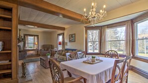 A dining area with a table set for four, wooden chairs, and a chandelier.