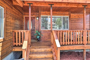 Stunning cabin with a central staircase leading to a cozy porch area.
