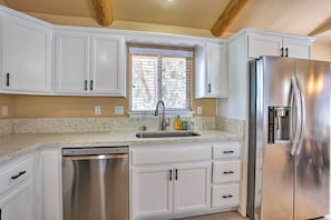 Enjoy cooking in this well-equipped kitchen with dishwasher, double sink, and stainless steel refrigerator.