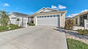 A residential house with a garage, a driveway, and a well-maintained lawn. - Golfer's Paradise - The Villages in Wildwood! (Wildwood)