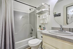 Enjoy a refreshing shower in the walk-in shower with a glass door, a white toilet, and a vanity with sink and mirror.