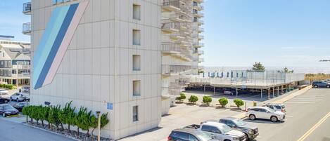 Un hotel de gran altura con balcones y un estacionamiento.
