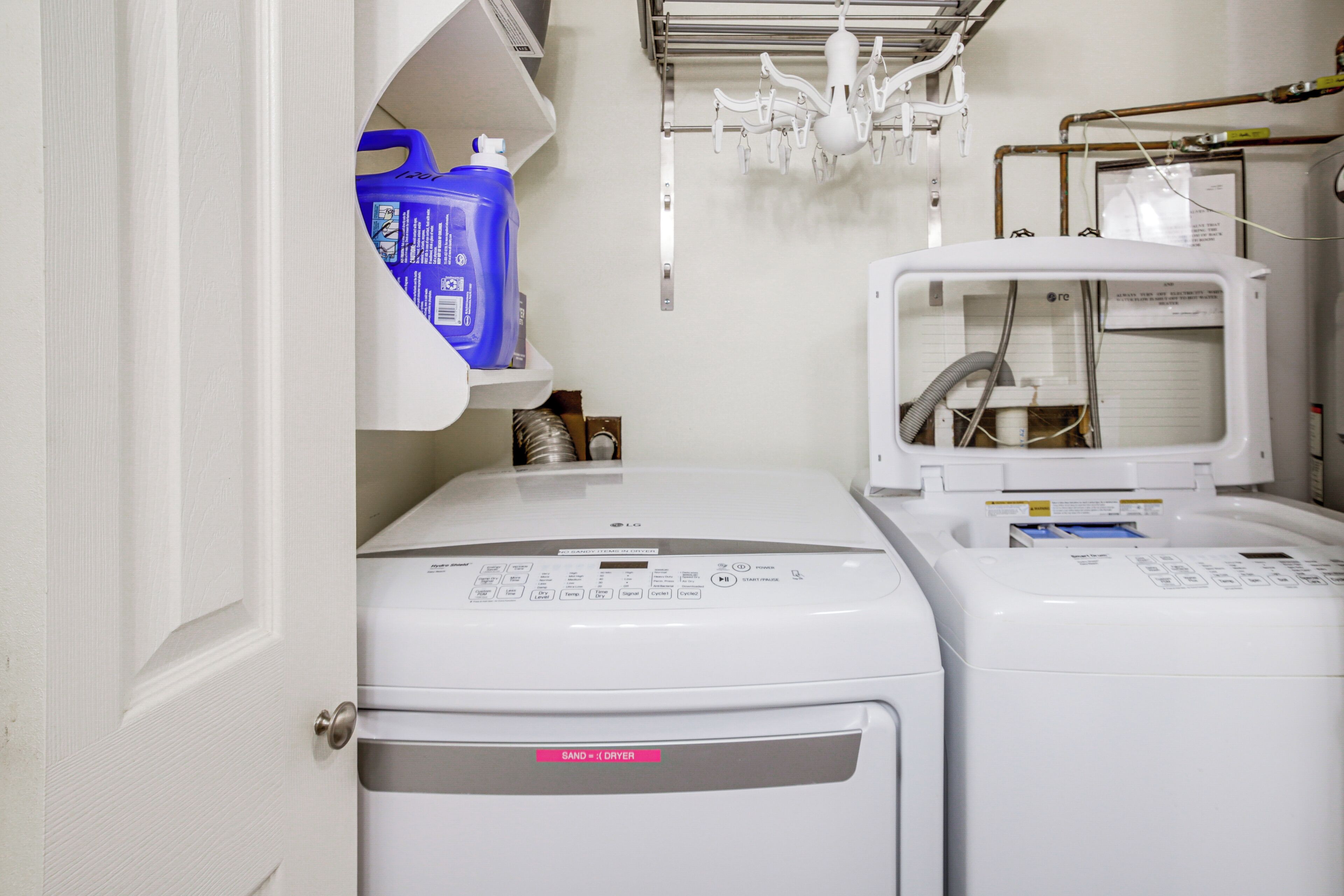 A laundry area with two washing machines and a dryer.