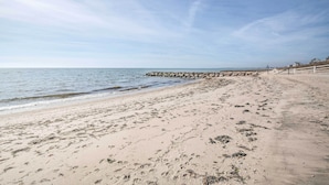 A sandy beach with a rocky breakwater and a clear sky. - Walk to Beach: Quaint Dennis Home w/ Deck + Grill! (Dennis Port)