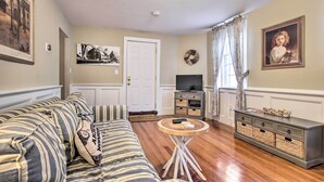 A living room with a sofa, a coffee table, a television, and a cabinet. - Inviting Salem Apartment Near Waterfront & Museums (Salem)