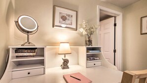 A bedroom with a bedside table, a lamp, a mirror, a bed, and a door. - Inviting Salem Apartment Near Waterfront & Museums (Salem)