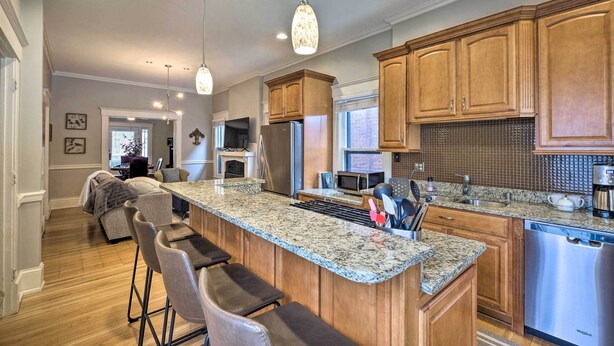 A modern kitchen with granite countertops, stainless steel appliances, and wooden cabinets. - Louisville Home w/ Hot Tub in The Highlands! (Louisville)