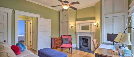A living room with a sofa, ottoman, and a fireplace.