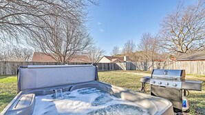 A hot tub with water flowing, a barbecue grill, and a wooden fence in a backyard. - Fayetteville Home w/ Hot Tub ~ 3 Mi to U of A! (Fayetteville)