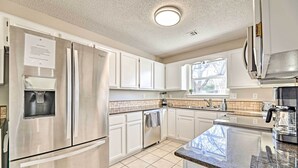 A modern kitchen with stainless steel appliances, white cabinets, and a granite countertop. - Fayetteville Home w/ Hot Tub ~ 3 Mi to U of A! (Fayetteville)