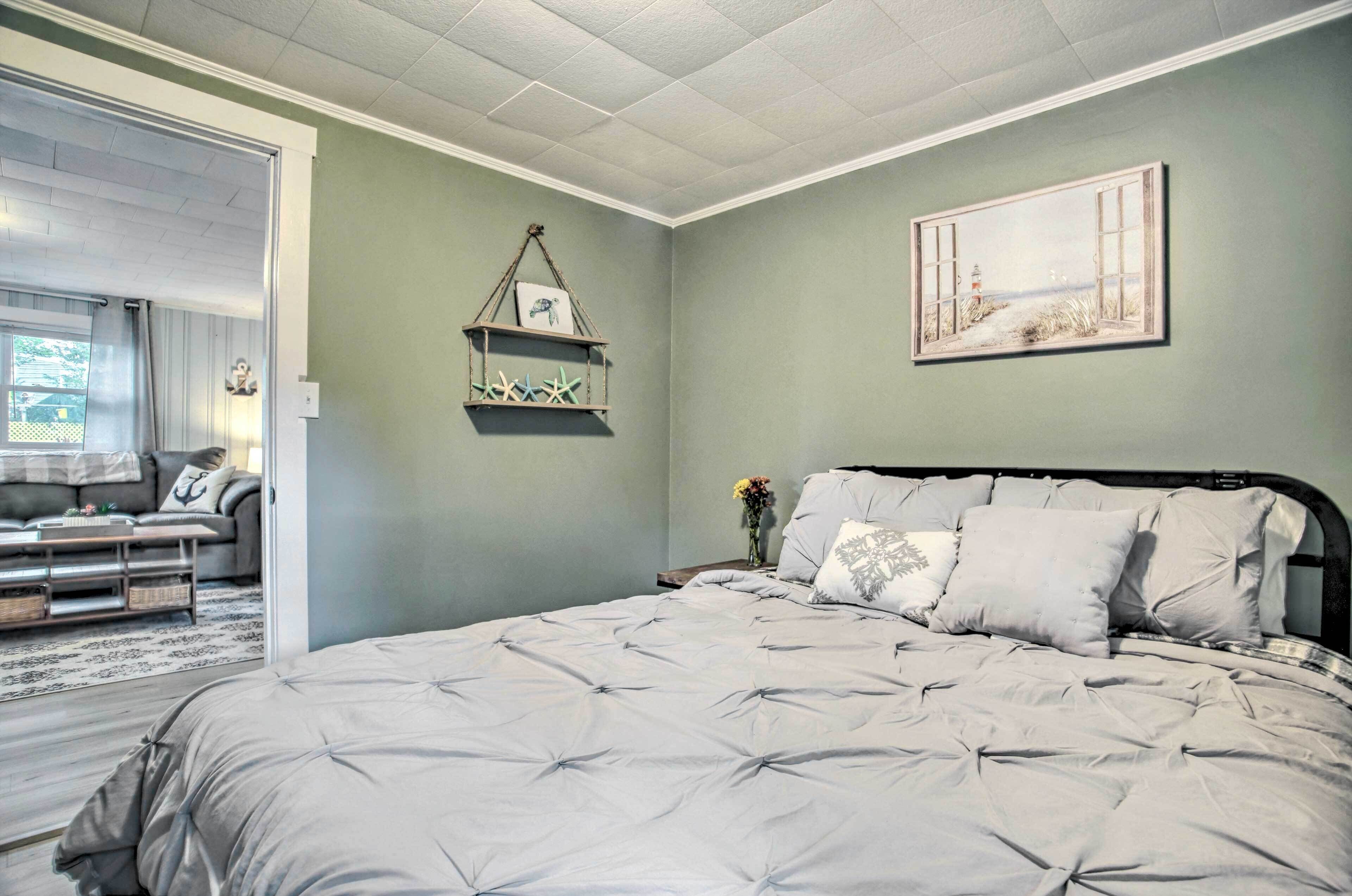 Um quarto com uma cama grande, um lustre pendurado e um quadro na parede.