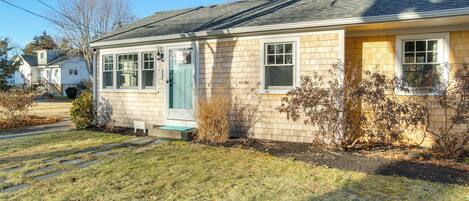 A single-story house with a front porch, a door, and windows.