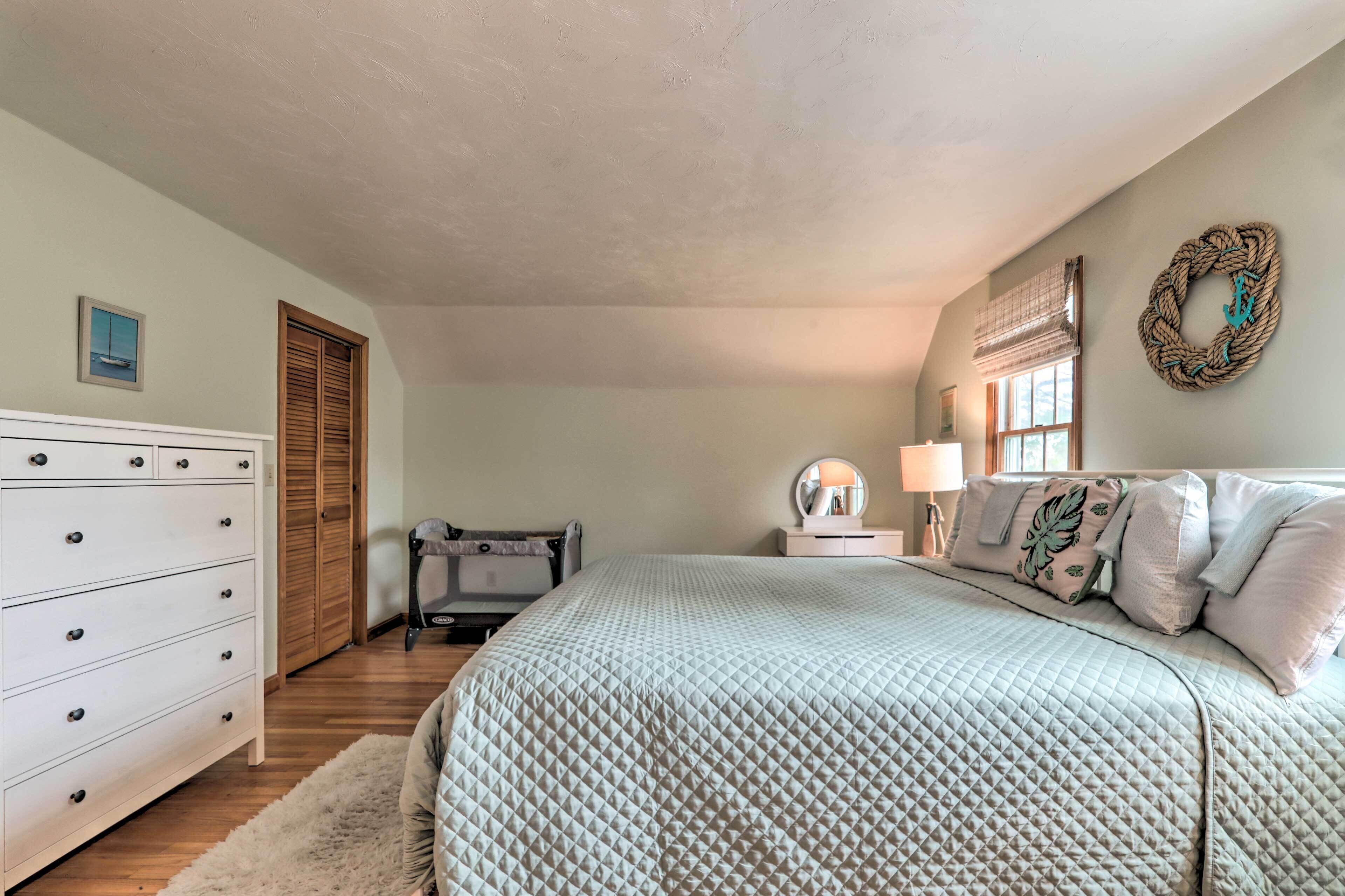 Une chambre à coucher avec un lit, une commode et une fenêtre équipée de stores.