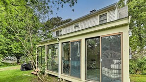 Een huis met grote glasramen en een overdekte veranda.