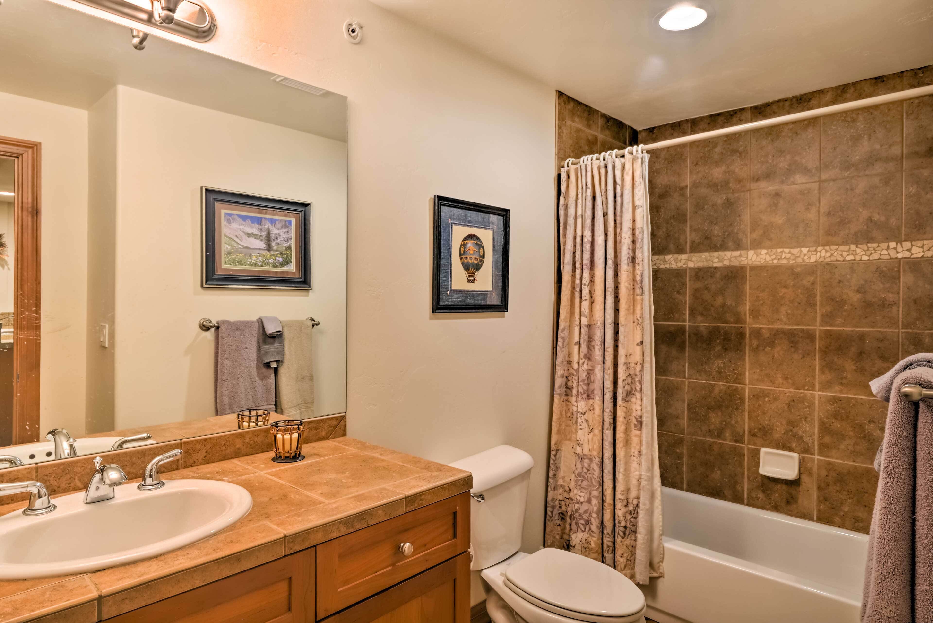 A bathroom with a sink, toilet, and bathtub.