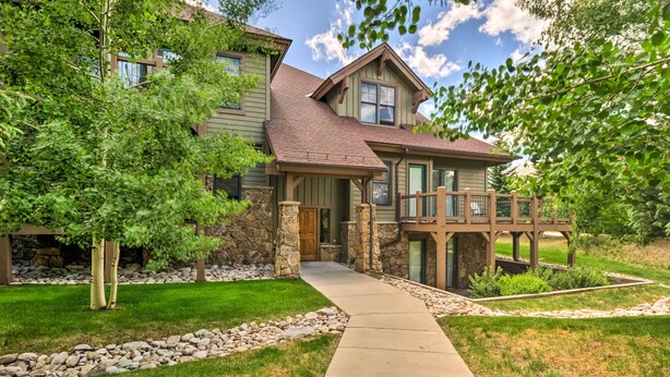 A two-story house with a stone foundation, a wooden deck, and a stone pathway leading to the front door. - 4 Mi to Breckenridge Resort: Condo w/ Sauna Access (Breckenridge)