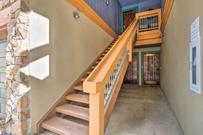 A staircase with wooden steps and a wooden handrail, leading to a door with a green frame. - Walk to Ski Lift: Renovated Condo in Breckenridge! (Breckenridge)
