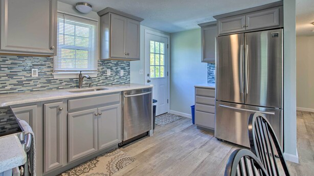 A modern kitchen with grey cabinets, stainless steel appliances, and a patterned backsplash. - Updated Plymouth Home < 2 Miles to Waterfront! (Plymouth)