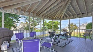 A covered outdoor patio with a table and chairs, a grill, and a view of the neighborhood. - Fantastic Plymouth House w/ Deck & Ocean Views! (Plymouth)