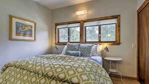 A bedroom with a large bed, a framed picture on the wall, and a window with a view of trees. - Great for Couples! Cape Cod Cottage 2 Mi to Beach (Wellfleet)