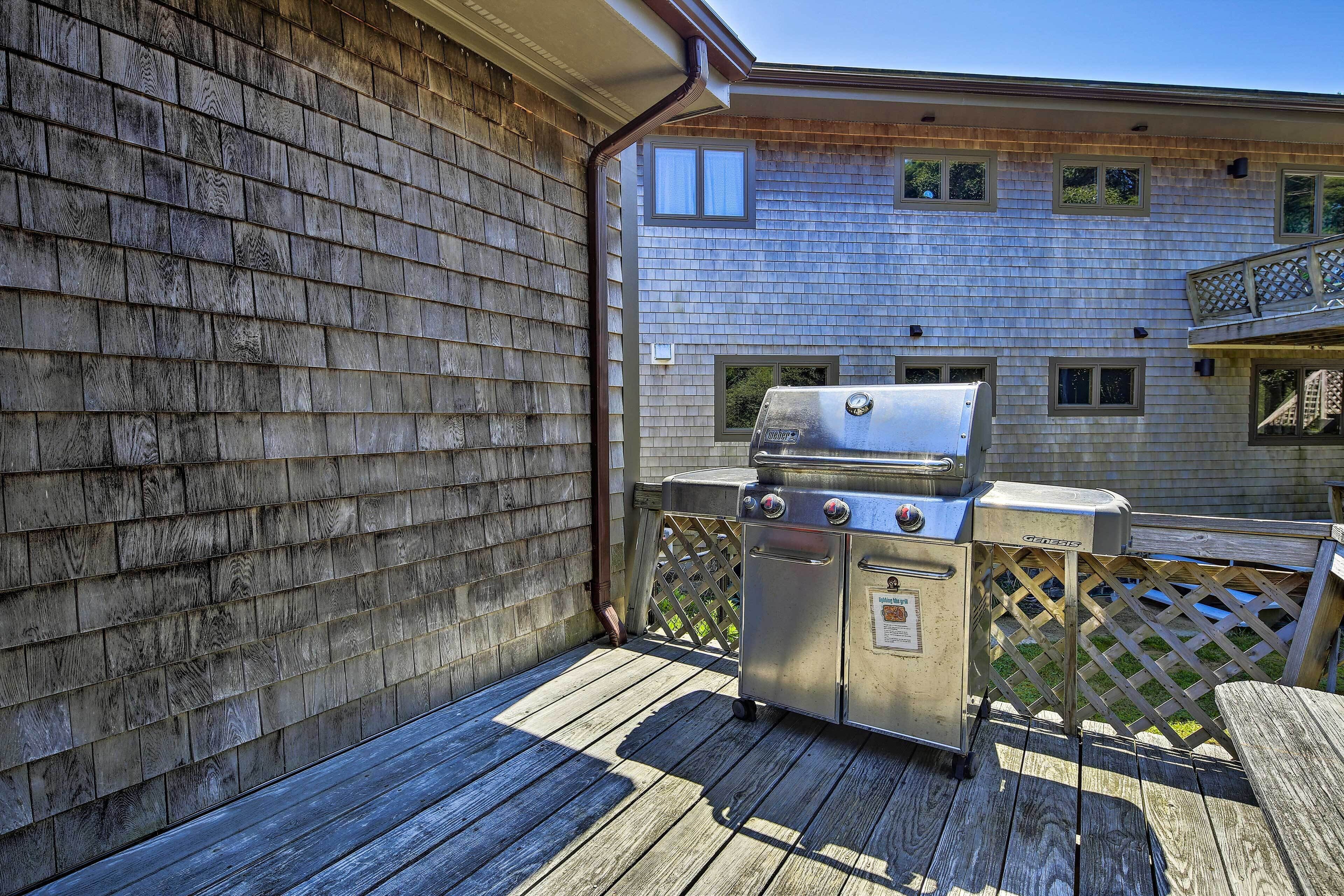 A covered outdoor area with a grill and a wooden deck.