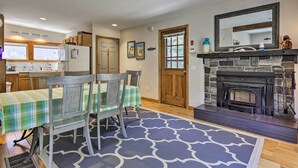 A kitchen with a dining table, chairs, a fireplace, and a window. - Great for Couples! Cape Cod Cottage 2 Mi to Beach (Wellfleet)