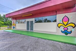 A building with a red roof, a green entrance, and colorful murals on the walls. - 'the Float Yard' Pensacola Home w/ Pool Table (Pensacola)