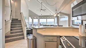 A modern kitchen with a central island, a built-in oven, and a stainless steel range hood.