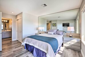 Ein Schlafzimmer mit einem großen Bett, Nachttischen, einem Spiegel und einem Kleiderschrank.