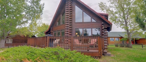 A log cabin with a deck and large windows.
