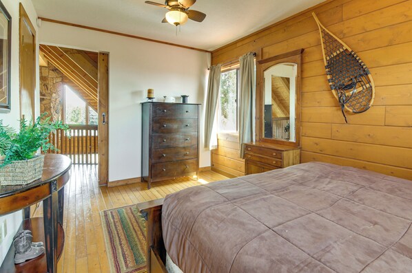 Une chambre à coucher avec un lit, une commode et un ventilateur de plafond.