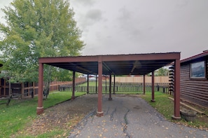 A covered outdoor area with a gravel path, wooden fence, and a metal roof structure. - Soco Pagosa Lakes Cabin w/ Deck & Grill! (Pagosa Springs)