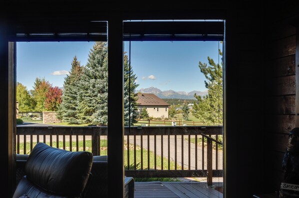 Ein Zimmer mit Blick auf ein Gebirge durch ein Fenster.